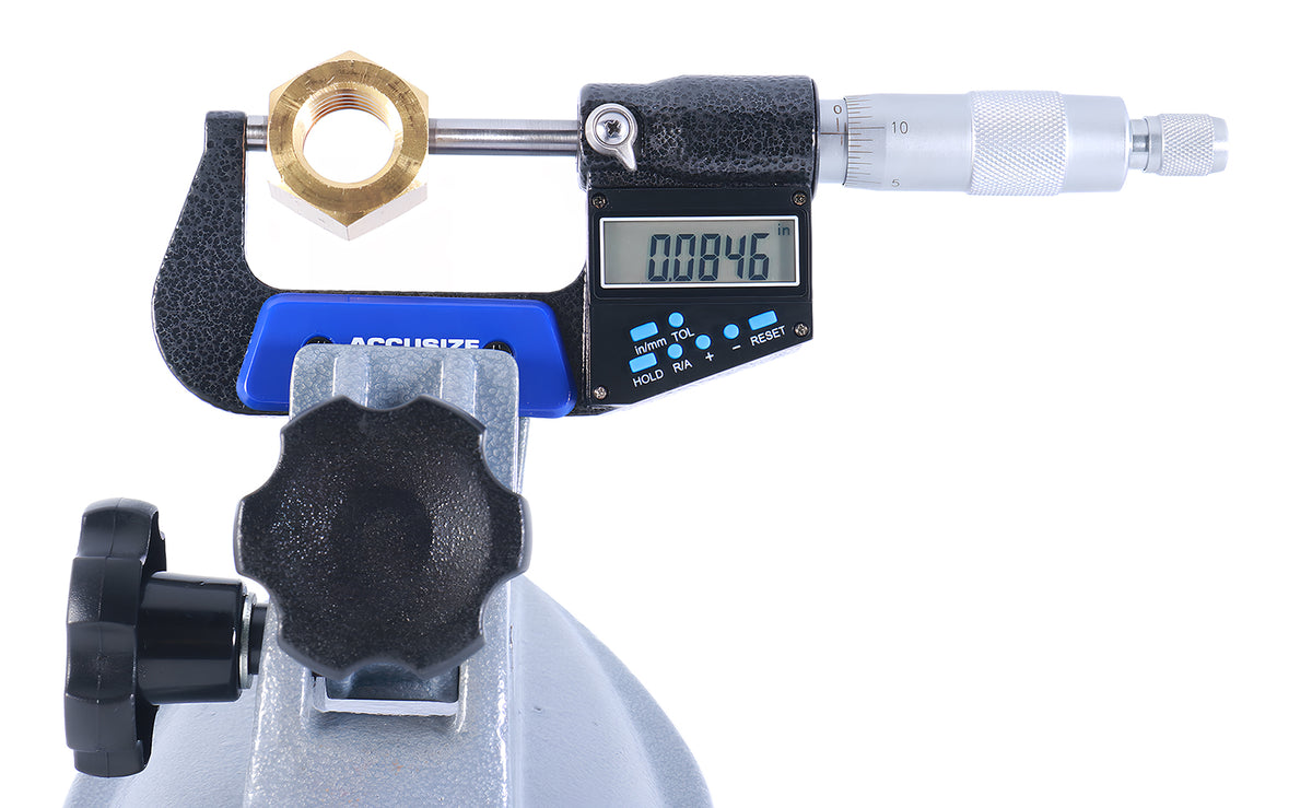 Electronic digital outside micrometer mounted on stand measuring hex nut, clear LCD display for precise dimensional inspection in workshop environment
