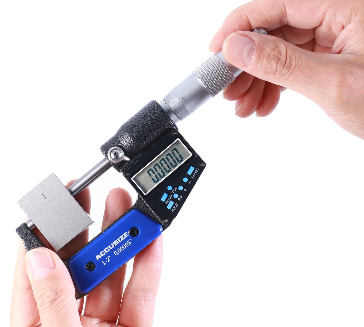 Hand adjusting electronic digital outside micrometer with large LCD display set to zero, demonstrating easy operation and precision measurement control